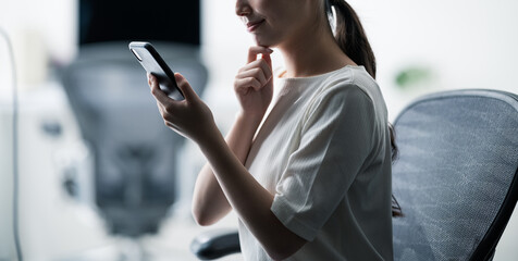 スマートフォンを見て考える女性