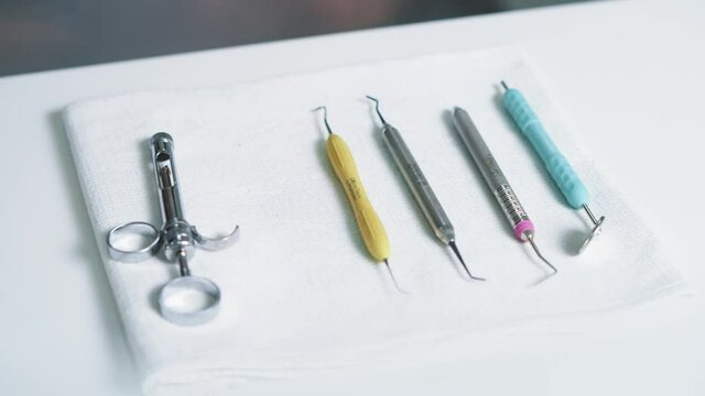 Dentist using professiona dental instruments on teeth treatment. Close-up of orthodontist taking away his medical tools. Oral hygiene and dental healthcare.