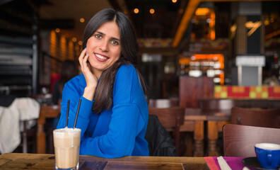 Portrait of pretty young woman in a cafe.