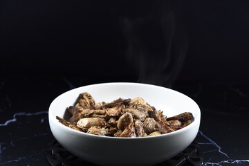 Traditional grilled mushroom stem or mushroom stipe with soy sauce and pepper in the bowl. Famous appetizer snack menu in Asia restaurant. Food in vegetarian festival concept. 