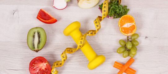 Fuits and vegetables, dumbbell for fitness and tape measure, concept of healthy lifestyles, nutrition and slimming
