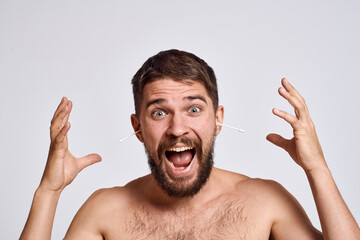 Bearded man with bare shoulders cotton swabs hygiene body care