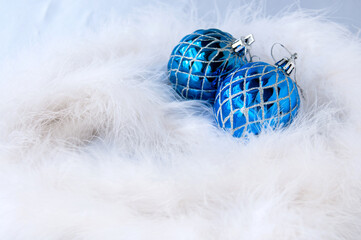 New year's still life: for a postcard, two blue Christmas balls on a white Swan's down, space for text