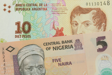 A macro image of a orange, plastic five naira note from Nigeria paired up with a colorful ten peso note from Argentina.  Shot close up in macro.