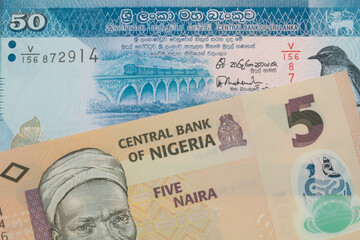 A macro image of a orange, plastic five naira note from Nigeria paired up with a blue and white fifty rupee bank note from Sri Lanka.  Shot close up in macro.