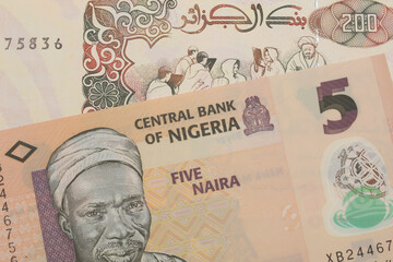 A macro image of a orange, plastic five naira note from Nigeria paired up with a beige 200 Algerian...