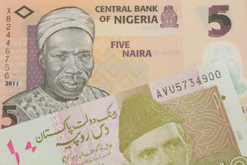 A macro image of a orange, plastic five naira note from Nigeria paired up with a pink and grey ten rupee note from Pakistan.  Shot close up in macro.