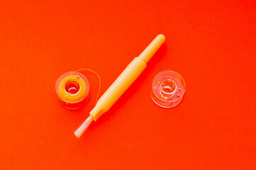 Industrial background. Sewing machine cleaning brush and thread spool