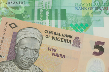 A macro image of a orange, plastic five naira note from Nigeria paired up with a green and white fifty shekel bank note from Israel.  Shot close up in macro.