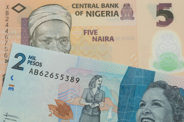 A macro image of a orange, plastic five naira note from Nigeria paired up with a blue two thousand bank note from Colombia.  Shot close up in macro.