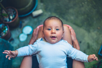 Fototapeta premium Baby resting in his mother's lap outdoors