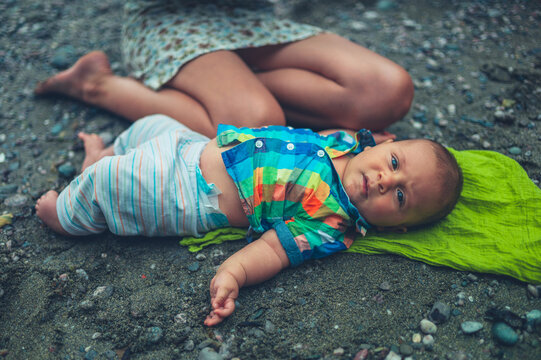 Little baby relaxing with his  mother on the beach