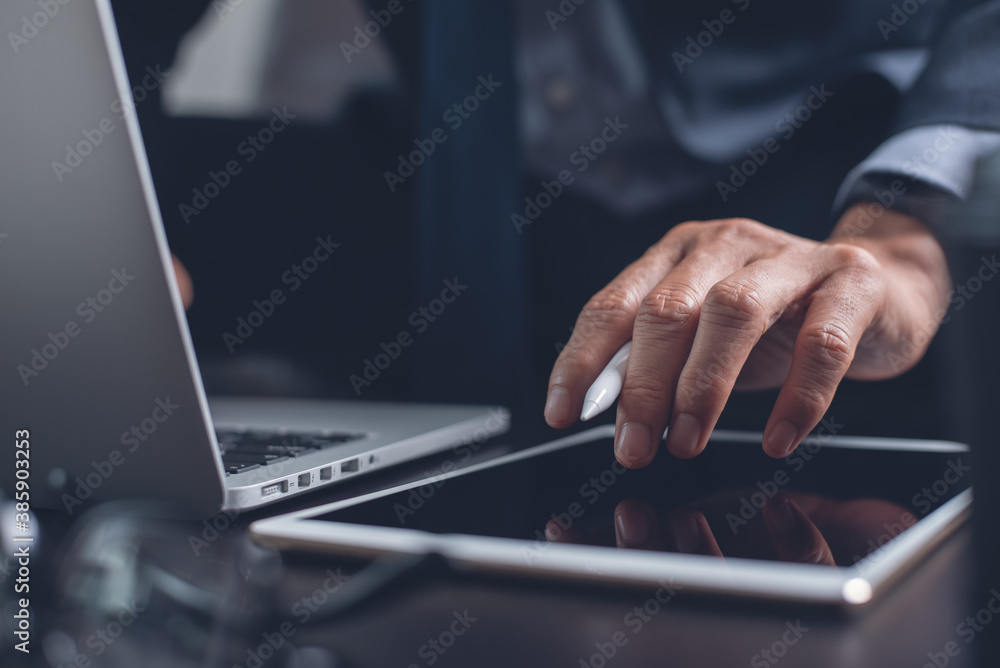 Poster businessman hand using on digital tablet touching on screen and working on laptop computer in office