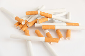 Cigarettes with a yellow filter lie on a white surface