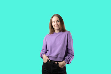 young caucasian woman on turquoise background in purple sweater. Happy millennial girl