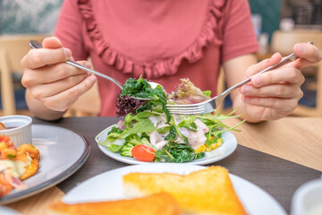 Young woman eating healthy food focus on hand and fork. soft focus. Copy space.