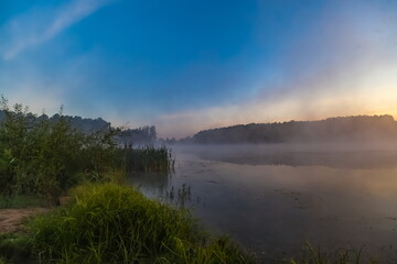 Fototapeta na wymiar Mist over the lake dawn early morning in the summer
