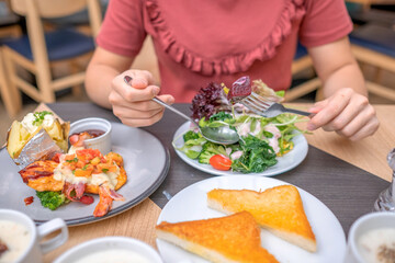 Young woman eating healthy food focus on hand and fork. soft focus. Copy space.
