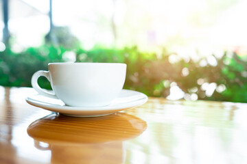 White coffee hot cup morning breakfast on wooden table with nature background. Hot cappuccino coffee. Copy space.