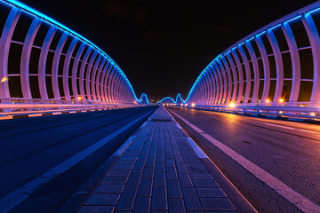 A night view of Meydan Bridge with blue lights - Powered by Adobe