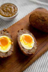 Homemade Scotch Eggs on a rustic wooden board, side view. Close-up.