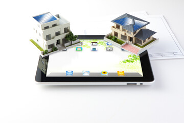 家の模型とタブレット型コンピューター