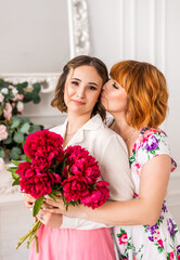 happy daughter giving mother a spring flower bouquet