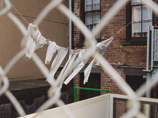 White laundry hung in the courtyard through the fence in Chinatown, New York