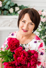 Beautiful senior woman at home with a bouquet of flowers. Happy Mother's Day. Beauty, fashion. Happy retirement.