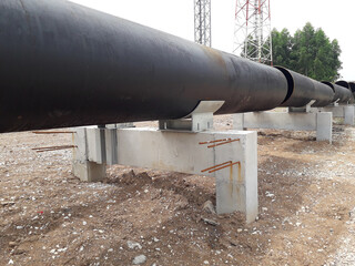 The new black metal pipe for raw water and steam  is overground, parallel to the road.
