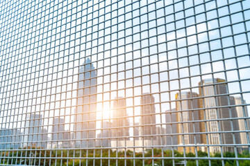   See the blurry city buildings through the iron net