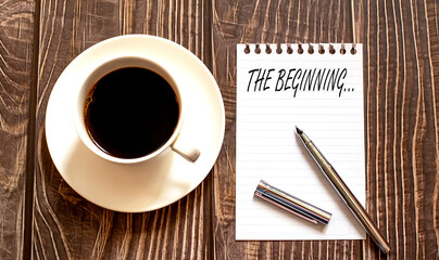 THE BEGINNING - white paper with pen and coffee on wooden background