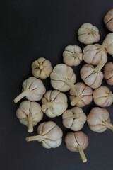 Bulbs of garlic (Allium sativum) on black background. Flat lay concept