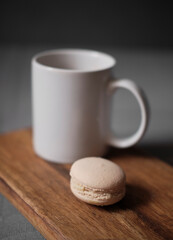 a cup of coffee with a cake. Vanilla macarons with a cup. French pastry on a wooden background. Macarons on wood