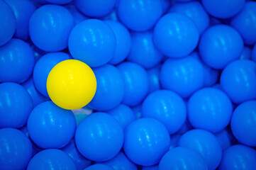 Close up of plastic yellow and blue balls at the playground. Soft focus. Background.