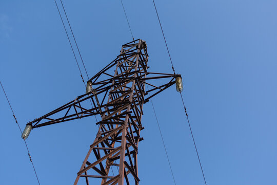 Steel structure of a power line support against a clear blue sky. Communication tower for power supply unit.