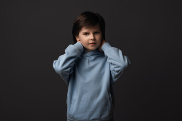 Image of Cute boy 10-12 years old smiling and looking at camera. Studio shot, gray background