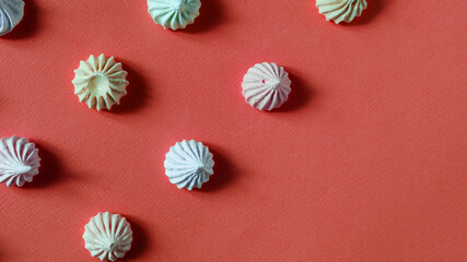 multicolored confectionery Bizet cakes on a bright red background place under the text