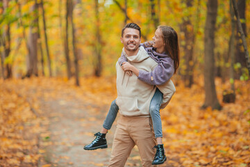 Fototapeta premium Family of dad and kid on beautiful autumn day in the park