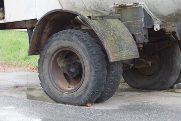 Fototapeta na wymiar big black dirty wheels on a gray truck on the street