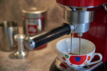 Brewing coffee with a coffee machine. Closeup of a coffee machine. Colorful mug.