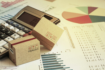 Packaging boxes with calculator and this type of financial charts include stacks of bar compare between the expansion of export business and increase the rate of goods each year.