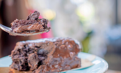Woman is eating chocolate browine cake. Copy space.