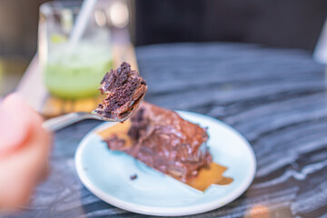 Woman is eating chocolate browine cake. Copy space.