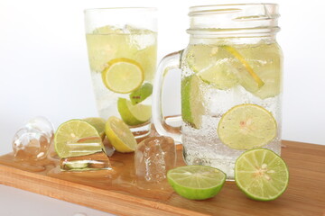 Health care, fitness, healthy nutrition diet concept. Fresh cool lemon infused water, detox drink, lemonade in a glass jug and a glass.