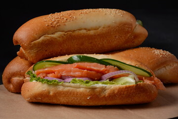Baguette sub sandwich with salmon fish, onions, cucumbers, lettuce