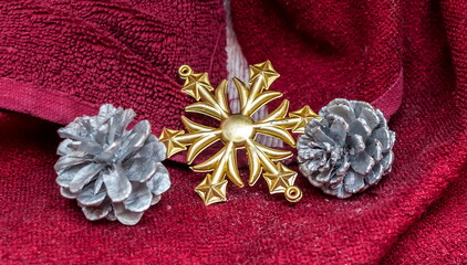 Christmas decorations on the Christmas tree (cones and Golden snowflakes) on a crimson background