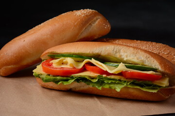 Sandwiches with cheese, lettuce, tomatoes and onion on a on a dark background