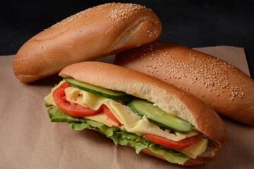 Sandwiches with cheese, lettuce, tomatoes and onion on a on a dark background