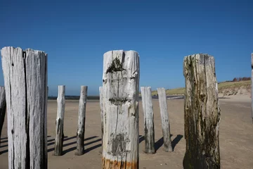 Foto op Canvas Wooden Posts of a beach erosion protection system along the beach at the town of Vlissingen in Zeeland Province in the Netherlands © Tjeerd